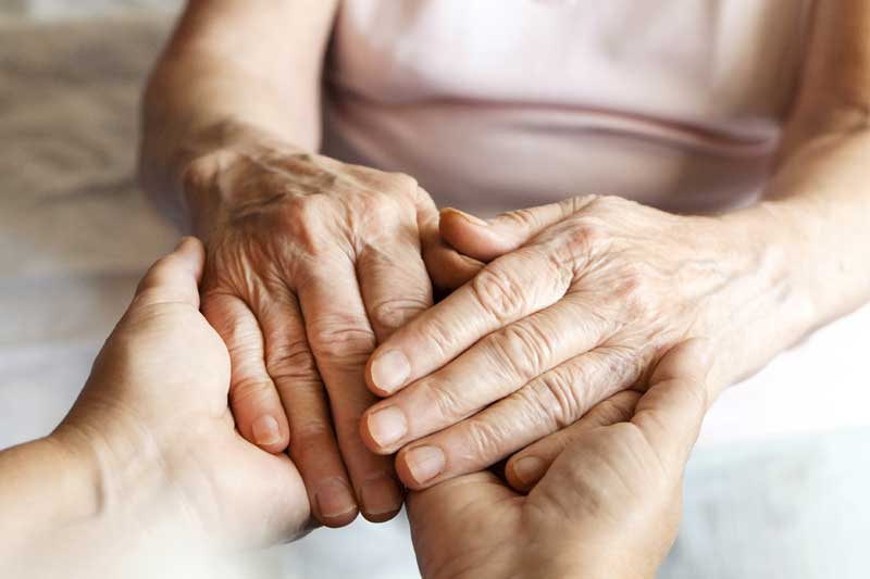 Mobility exercises for seniors: A senior engages in finger and hand stretches to increase dexterity and reduce stiffness.