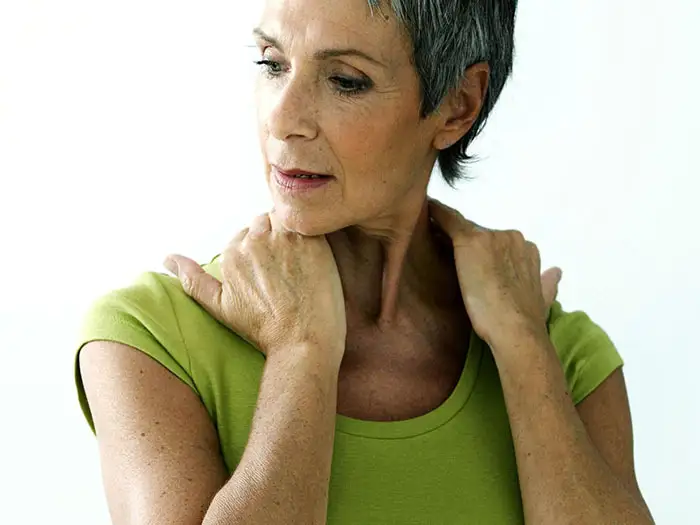 A senior tilting their head towards one shoulder, relaxing into the stretch.