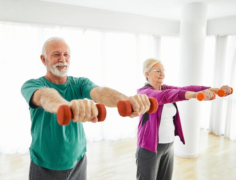 Mobility exercises for seniors: A senior engages in seated arm circles to enhance shoulder flexibility.