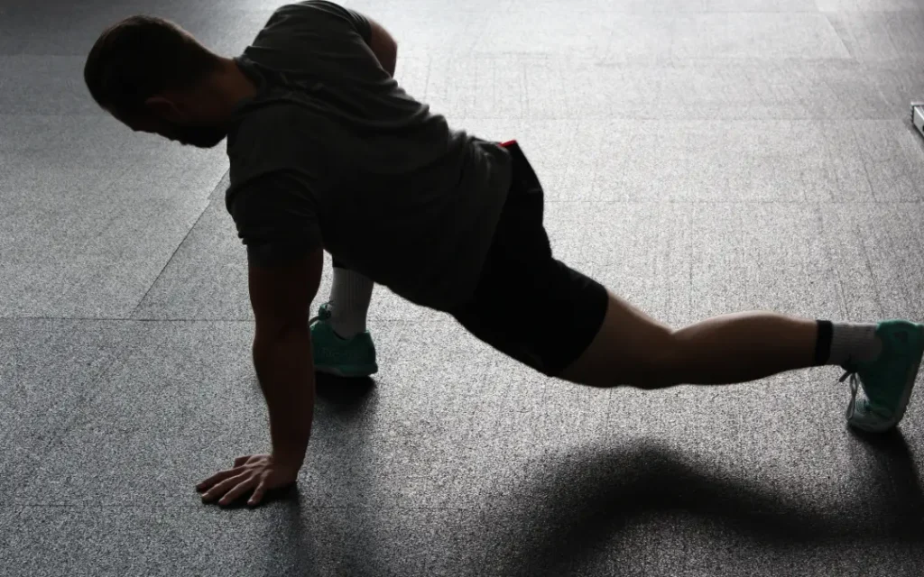 A person performing a no-equipment workout routine at home, including exercises like bodyweight squats, push-ups, and planks