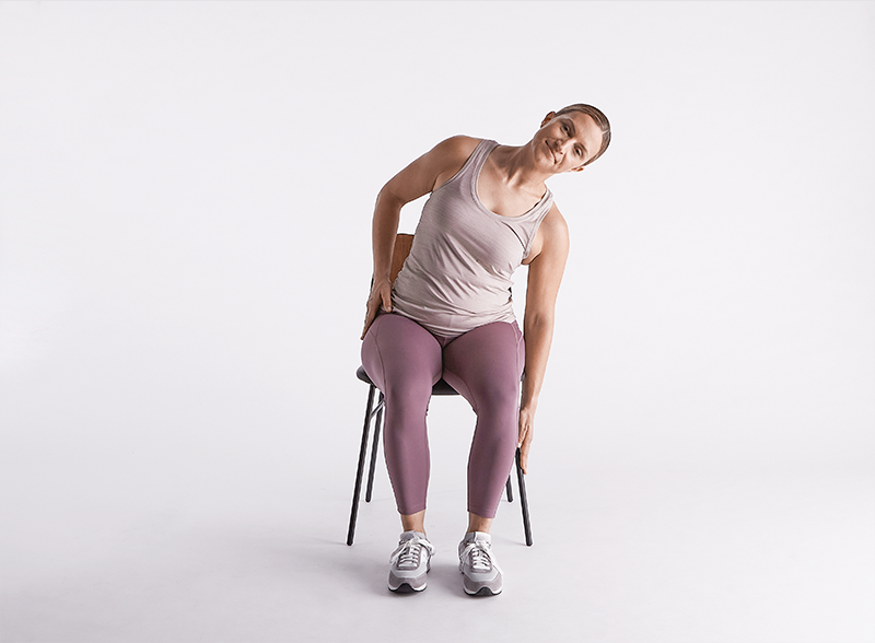 Mobility exercises for seniors: A senior practices seated side stretches to enhance torso flexibility.